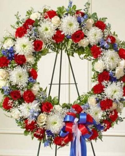 <p>This beautiful red, white and blue wreath is a dignified expression of your feelings of love and care for a beloved veteran or patriot. Exquisitely crafted by our expert florists, it features the freshest red and white roses, blue delphinium and more accented by vibrant greenery creating an unforgettable tribute to honor their life. Appropriate for family, friends and business associates to send directly to the funeral home.</p>