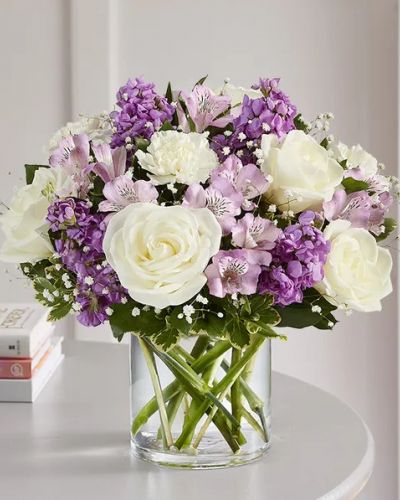 <p>Lovely memories are made with thoughtful gifts for the ones we care about. Our charming bouquet is loosely gathered with a medley of lavender & white blooms. Hand-designed inside a clear cylinder vase with cascading greenery all around, it’s a wonderful way to express the sentiments you have inside your heart.</p>