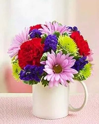 <p>Send best wishes with this cute mug of seasonal fresh flowers. Colors may vary.</p>