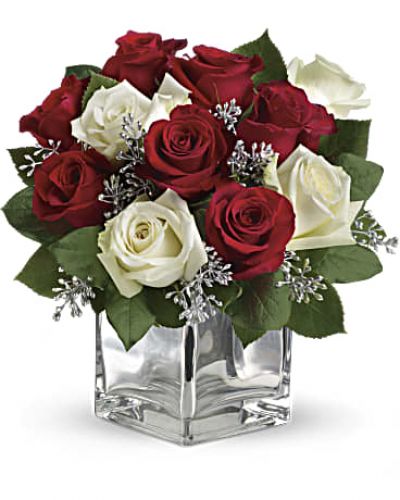<p>Give Christmas a charmingly contemporary spin with lush red and white roses in a dazzling mirrored silver cube. With a merrily moderate price tag, it makes the perfect gift for all the people on your list – naughty or nice.</p>
<p>The impressive bouquet includes red roses and white roses accented with assorted greenery.</p>